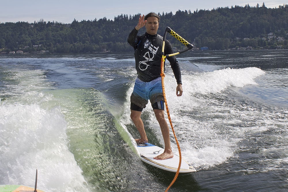 Surfboard behind outlet boat