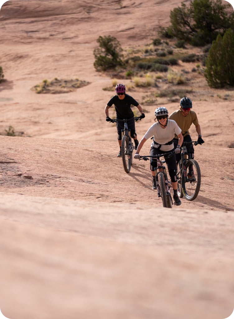 Three mountain bikers approaching a hill