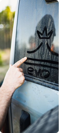 An evo logo drawn onto a dusty car window